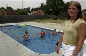 Tammy Miller, of Rossford, likes her 14-by-28-foot pool that is wide enough for these three swimmers.