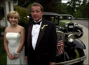 CLASSY AND CLASSIC: Co-Chairpersons Kim Starr and Joe Luzar look classy next to classic cars at the Mystery Ball. 