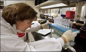 Medical technologist Mary Lavoy works in the Medical College of Ohio Hospitals lab, which has a steel cage surrounding it to prevent illegal entry.