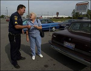 Sgt. Jim Goodenough of the Lake Township Police Department issues Shirley Witt of Martin a good-driving coupon for Marco's Pizza.