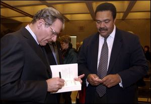 Washington Post's Bob Woodward autographs one of his books for Toledo Mayor Jack Ford at the Great Hall.