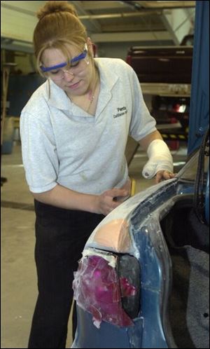 Angela Glambin, a senior from Luckey, sands a car in the automotive collision repair lab at Penta Career Center.
