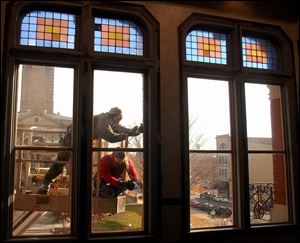 reg rover18p November 18, 2002. Eric Fourtner and Beth Brown of Rustain seal cracks in the windows of the Kagy building in downtown Tiffin, O. Blade photo by Jeremy Wadsworth