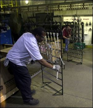 Leroy Suton prepares parts for the coating line at MetoKote's operation in Monclova Township.