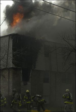 Ten pumper trucks and four ladder trucks respond to the three-alarm apartment blaze.