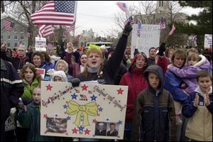 Vicki Bickley, carrying a poster with photos of her son, shows her support for U.S. Troops fighting in Iraq.