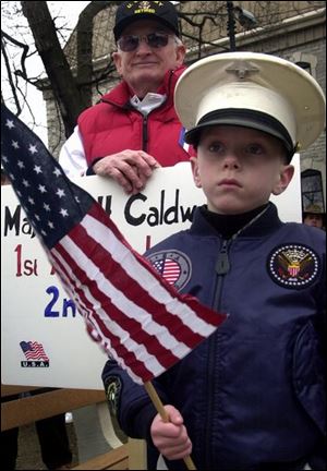 Tyler Hobson, 8, and Jim Caldwell, whose son is fighting in Iraq for the second time, listen as families of service members share their stories.