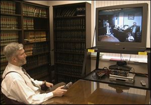 Maumee Municipal Judge Gary Byers tests his arraignment gear on workers at Corrections Center of Northwest Ohio in Stryker, Ohio. Camera equipment and microphones are located under the television set.