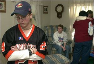 Pfc. Juan Guadelupe Garza's wife, Casey, left, wears her husband's high school football jersey in memory of him as family members console one another. The couple got married Dec. 26.