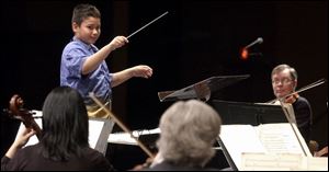 The Toledo Symphony Orchestra performs at the Stranahan Theater under the baton of Joey Ybarra. The orchestra let area youths try their hand at conducting yesterday.
