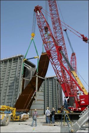 Crews install 80-foot-long `tube bundles' of flexible steel in the boilers of the Calpine plant in Sandusky Township.