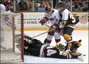 Cincinnati goalie Greg Hewitt makes a save as Steve Rodberg tries to get Toledo's Tim Verbeek out of the way.