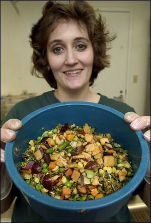 Julie Reynolds has prepared a meal in a bowl for the Gambel's quails at the Toledo Zoo: Among the apples, grapes, carrots, and leafy greens are live worms. 