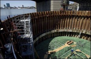 Iron workers install steel-reinforcing bars in a coffer dam for the new Maumee River Crossing's central pylon. The pouring of concrete is scheduled to begin this morning and take about 36 hours.