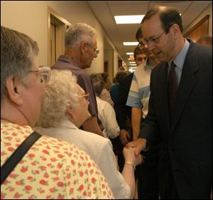 Gov. Bob Taft shakes hands with Roma Benet.