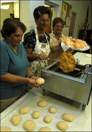 Shirley Razzoog, left, Joanne Eberflus, and Sharon Grzywinski make zalabee for the St. George festival.