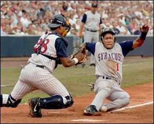 Syracuse's Jimmy Alvarez slides into the plate — and the ball — as Toledo catcher Yohanny Valera can't handle the throw from left fielder Ernie Young. Alvarez scored from second on Mike Colangelo's two-out single in the seventh inning. The run tied the score at 3-3.