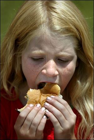 Brionna Begin, 8, samples the chef's work at Wildwood Preserve Metropark.