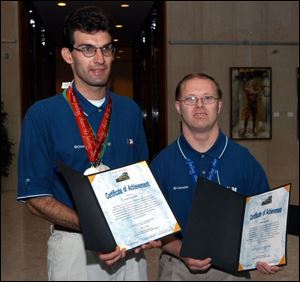 Andy Palmer and James Reiter show the certificates of achievement given them by Lucas County commissioners.