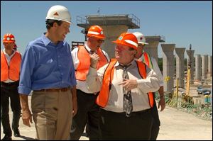 Calling the results so far `fascinating' and `unbelievable,' Gov. Bob Taft tours the Maumee River Crossing construction site in East Toledo with State Rep. Peter Ujvagi, right, and state transportation officials. The $220 million project is to be completed in August, 2005.
