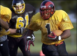 Rogers' Terrance Summers tries to pick up some yardage for the Gold.