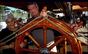 FULL SPEED AHEAD: Adela and Al Mundt take an imaginary turn at the helm of the Pride of Baltimore II during the Huntington Tall Ships Toledo festivities.