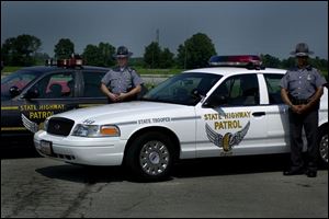 Highway Patrol troopers Ryan Stewart and Ron Anderson are beside a new white patrol car.
