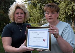 Sisters Susan Sevra, left, and Sharon Cutcher hold tributes to their mother, Shirley Thomson of Northwood.