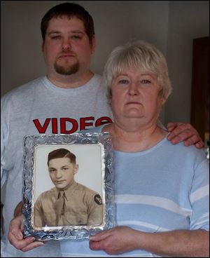 Pam Szczcpanski, 56, and son Todd, hold a photo of Robert Dolve. She has spent years asking for the full story behind her father's death. Todd, 31, joined her five years ago.