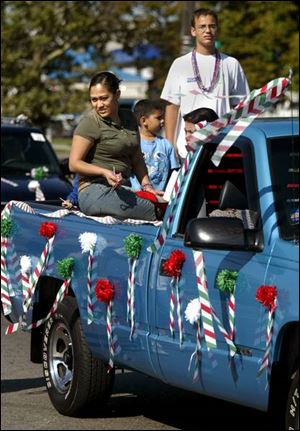 Participants in the Hispanic Heritage Month parade in South Toledo prepare to toss candy from a pickup.