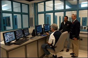Sgt. Tad Kluck, Dale Mitchell, director of detention, and Judge Brad Culbert of Sandusky County Juvenile Court view the computerized control room of the new detention center.
