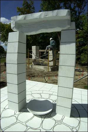 Sculpture technician Mike Barker is framed by a model of the memorial. The local chapter of the Ancient Order of the Hibernians initiated the $40,000 project.