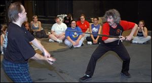 John Lennox, left, acts as a foil for Tony Wolf as he shows Adrian College students how he choreographed the sword-fighting scenes in The Lord of the Rings and other productions.
