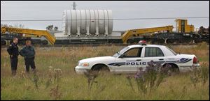 Walbridge police officers Rick Solether and Kenny Hetrick guard train and reactor from protesters at the Walbridge stop.
