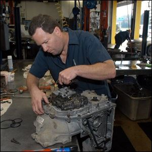 Ernie Burgess rebuilds a transmission at Cottman Transmission Center at 5230 Airport Highway. The center is close to being the second largest of 385 