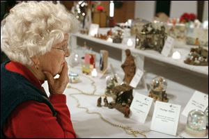 Adell Kettle of Pemberville studies many of the Nativity scenes on display at Bowling Green Alliance Church during the church's annual exhibit. 