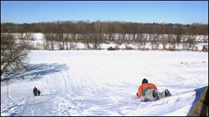 Nbr  snow25p  Ft. Meigs sledding hill.  Sledders have a great ride - It was only 12 degrees out and  the snow was fast.  Diane Hires  1/24/04