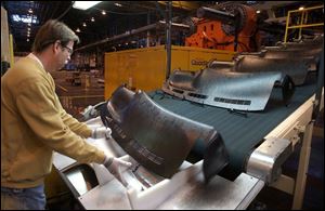 Mark Morris retrieves a component at the Adrian, Mich., Delphi plant, which is to make dashboards for two upcoming pickup-truck models.