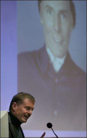 Dr. Oswald Steward praises actor Christopher Reeve, shown in background, for his involvement in the field.