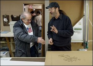 John Vance, left, thanks Bill Chapin for signing the back of a framed artwork.