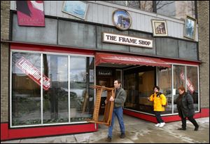Matt Jasin carries out a table at the shop's liquidation sale 