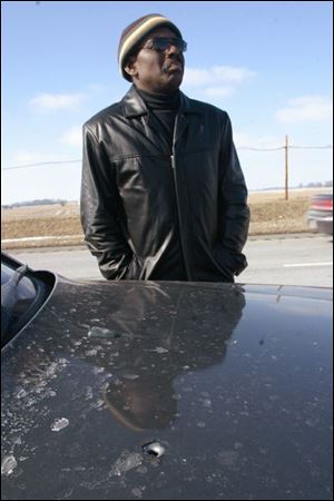 Douglas Berry looks over the Brock Road overpass on I-71, where he says a gunman stood as he fired into his Mercedes.
