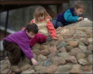 Nbr  Burnham Park, Sylvania, Ohio.  l-r  Jonah Kadens 5, Grace Cappellini 4, and Owen Cappellini 6, look for pennies stuck in the rock crevices of the fountain in the park.  The fountain is shut off for the winter - the kids arent getting rich, but its fun like a treasure hunt.  Diane Hires  1/3/03