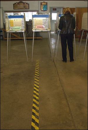 A solitary voter makes her selections on the ballot at the fire station in Haskins, Ohio.