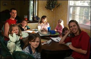 Amy Mathews, right, and her husband, Dan, left, with their daughters, clockwise: Kim, 8; Molly, 7; Heidi, 10; Hannah, 6; Olivia, 3; and Brittany, 4, at their Northwood home.