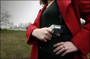 Concealed-carry records are exempt from most of the state’s public records laws. A woman demonstrates how her handgun is concealed. 