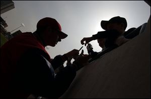 Mud Hens pitcher Eri Eckenstahler signs autographs for young fans in the record crowd that turned out yesterday.
