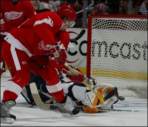 Detroit s Henrik Zetterberg slips the puck past the outstretched glove of Nashville goaltender Tomas Vokoun.