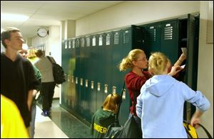 At the new Evergreen Middle School, seventh graders Liz Doxsee, kneeling, Cailen Ball, center, and Katie Coutcher, right, check out the lockers. They had praise for the school.