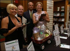 READY, SET, AUCTION: With pens poised, Laura and Thomas Baird, left, and Kirk and Lacey Young prepare to bid.